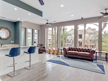 clubhouse with bar seating and sofa in front of large windows
